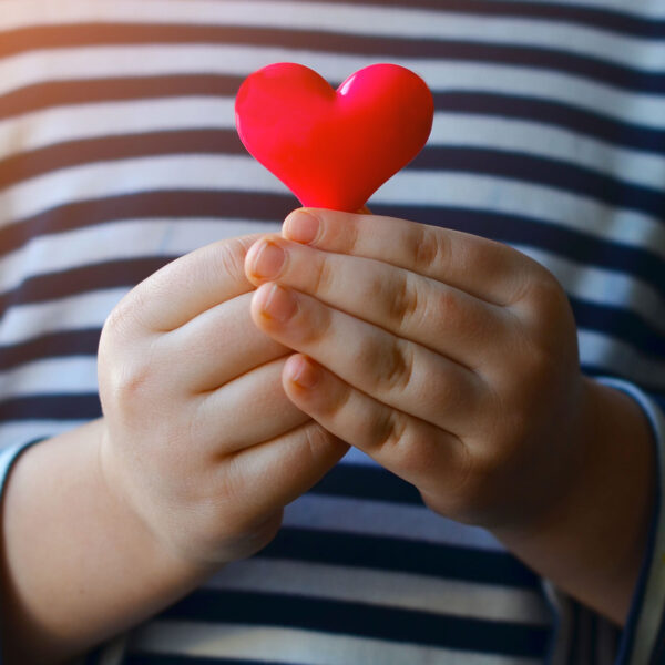 Les mains d'un enfant qui tient un cœur